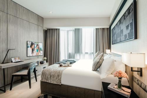 Habitación de hotel con cama y escritorio en Ascott Star KLCC en Kuala Lumpur