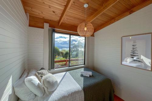 een kleine kamer met een bed en een raam bij HEXAGON BEACH HOUSE Binalong Bay of Fires Views in Binalong Bay