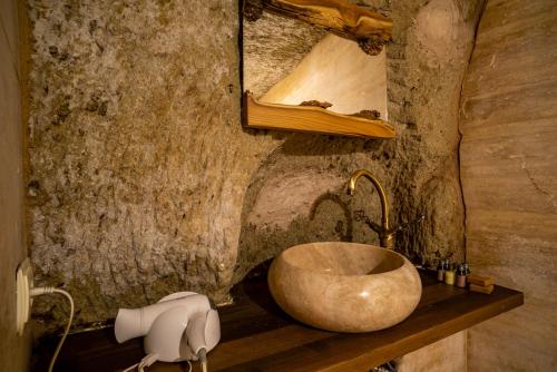 a bathroom with a sink in a stone wall at Cappadocia Snora Cave in Nevsehir