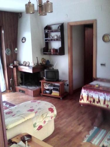 - un salon avec un lit et une télévision dans l'établissement Appartamentino, à Camigliatello Silano