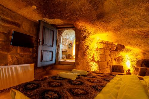 a bedroom with a bed in a stone room at Cappadocia Snora Cave in Nevsehir