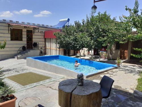 a person in a swimming pool in a backyard at Guest House LEADER in Ijevan