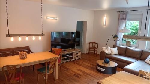 sala de estar con sofá y TV en Casa Verde Sinnerthal, en Neunkirchen