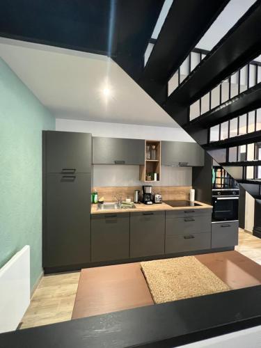 une grande cuisine avec des placards gris et une cuisinière dans l'établissement La Manufacture du Sable, à Berck-sur-Mer