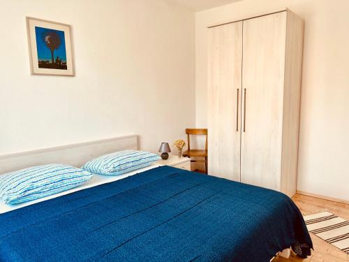 a bedroom with a blue bed and a cabinet at Villa Roseal in Povljana