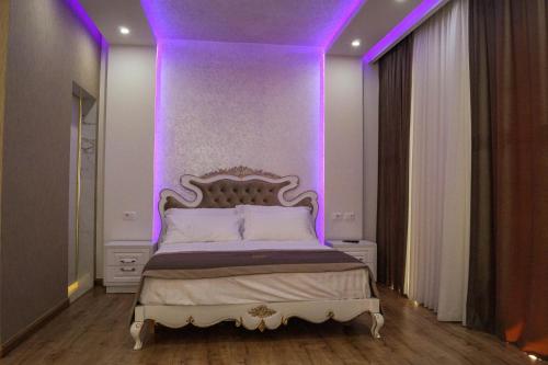 a bedroom with a bed with purple lighting at Red Hill Hotel in Tirana