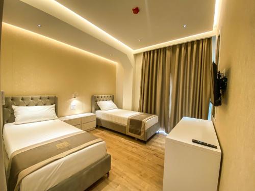 a hotel room with two beds and a window at Red Hill Hotel in Tirana