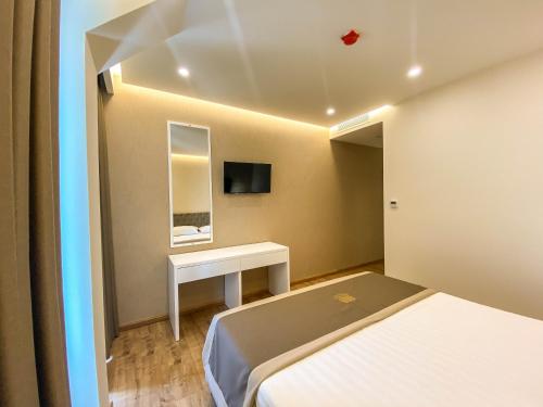 a room with two beds and a table and a mirror at Red Hill Hotel in Tirana