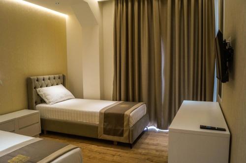 a hotel room with a bed and a window at Red Hill Hotel in Tirana