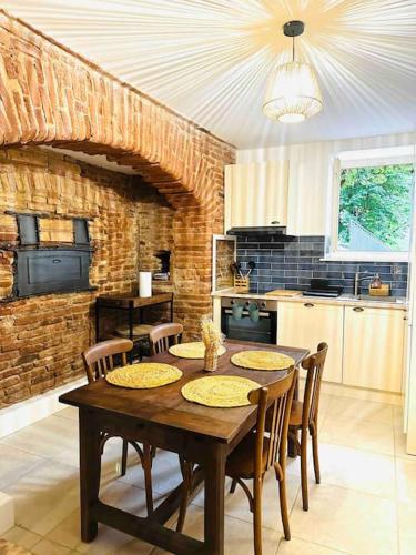 - une cuisine avec une table et des chaises en bois dans la chambre dans l'établissement La voûte du 26, à Albi