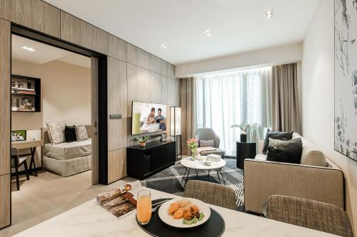 a living room with a table and a living room at Ascott Star KLCC Kuala Lumpur in Kuala Lumpur