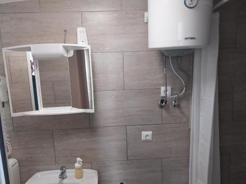 La salle de bains est pourvue d'un lavabo et d'un miroir. dans l'établissement Apartments Residence By, à Poreč