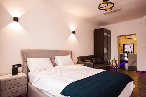 a bedroom with a large bed and a living room at Fagaras City Center Experience in Făgăraş