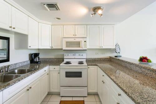 a kitchen with white cabinets and a stove top oven at Beach Living at Island Pine Villas BLP in George Town