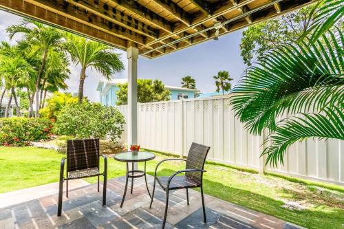 a patio with a table and chairs and a fence at Beach Living at Island Pine Villas BLP in George Town