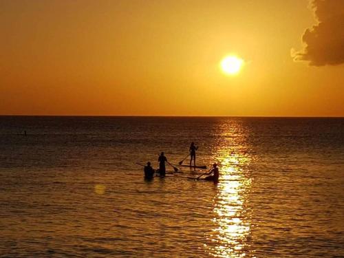 a group of people in a boat in the ocean at sunset at Beach Living at Island Pine Villas BLP in George Town