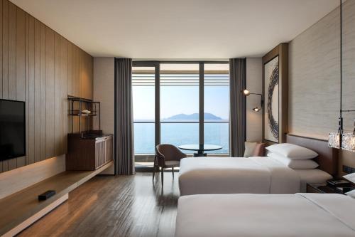 ein Hotelzimmer mit 2 Betten und einem TV in der Unterkunft Sheraton Ningbo Xiangshan Resort in Xiangshan