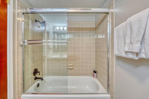 a bathroom with a bath tub with a glass shower at Riverfront family-friendly condo in Avon