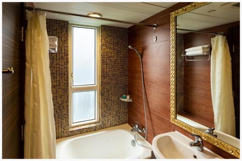 a bathroom with a tub and a sink and a mirror at Ramada Hong Kong Grand in Hong Kong