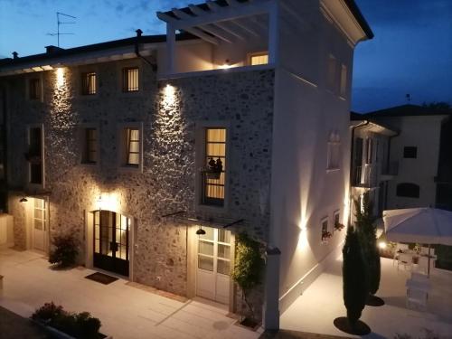 a large stone house with lights on the facade at Relais Ca' Morenica in Valeggio sul Mincio