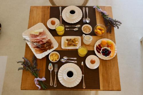 a wooden table with breakfast foods and drinks on it at Relais Ca' Morenica in Valeggio sul Mincio