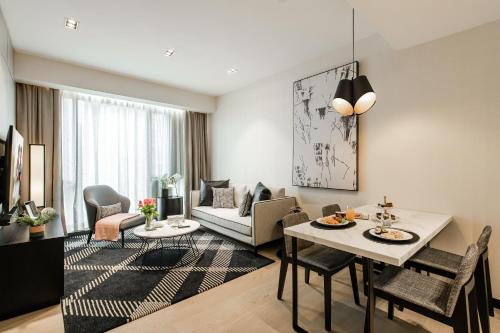 a living room with a table and a dining room at Ascott Star KLCC Kuala Lumpur in Kuala Lumpur