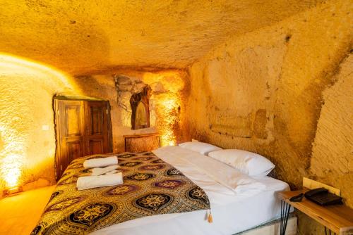 a bedroom with a bed in a stone room at Cappadocia Snora Cave in Nevsehir