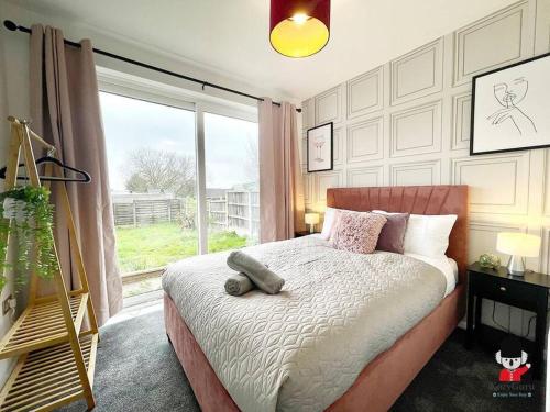 ein Schlafzimmer mit einem Bett und einem großen Fenster in der Unterkunft Oldham Newly Lovely 2BR 3Beds Bungalow UOLD158 in Moorside