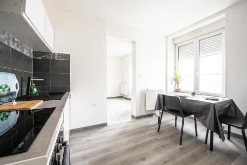 - une cuisine et une salle à manger avec une table et un évier dans l'établissement Oasis Mulhousien - RDC, wifi, parking, à Mulhouse