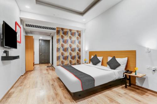 a hotel room with a bed and a tv at Collection O Hotel Landmark in Lucknow