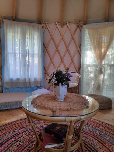 a room with a table with a vase of flowers on it at Love Frequency - יורט קסום במתת in Mattat