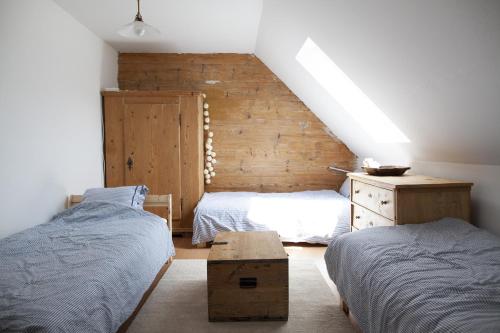 a bedroom with two beds and a wooden wall at Monika am Masenberg in Vorau