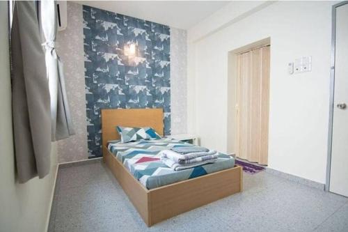 a bedroom with a bed with a blue wall at Peace Casa - Homely & Cosy in Butterworth