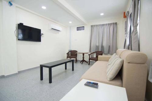 a living room with a couch and a tv at Peace Casa - Homely & Cosy in Butterworth