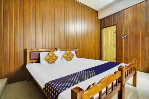 1 dormitorio con 1 cama grande y paredes de madera en SPOT ON Aiwa Residency en Muttam