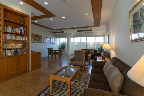 a living room with a couch and a table at Classic Kameo Hotel and Serviced Apartments, Sriracha in Si Racha