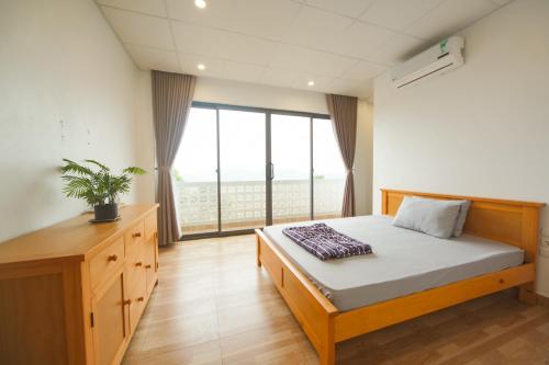 1 dormitorio con cama y ventana grande en Nature Key Retreat Gia Trịnh - Ba Vì, en Hanói