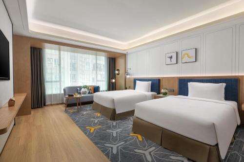a hotel room with two beds and a television at voco Guangzhou Shifu, an IHG Hotel - Free shuttle between hotel and Exhibition Center during Canton Fair & Exhibitor registration Counter in Guangzhou