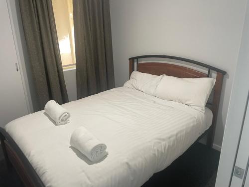 Una cama con dos rollos de toallas de papel. en Frangipani, en Albany
