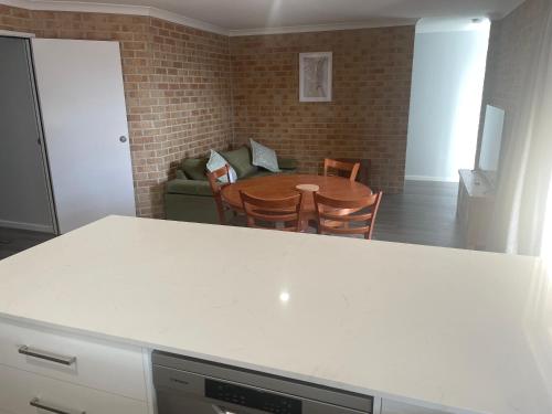 a kitchen and dining room with a table and chairs at Frangipani in Albany
