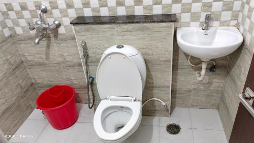 a bathroom with a toilet and a sink at Hitech Shilparamam Guest House in Hyderabad