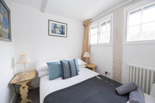 a bedroom with a bed and a desk and two windows at Linden Grove - 2 Bed City Centre Cottage in Kent