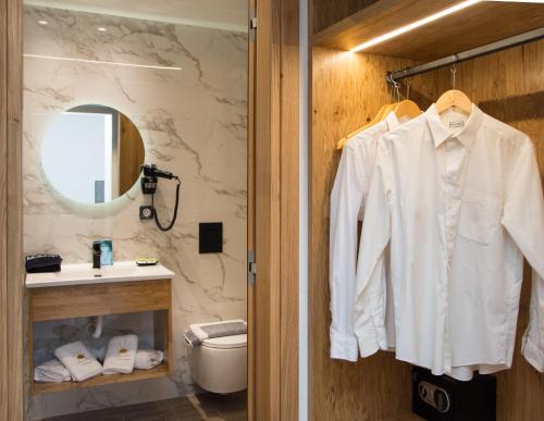 a bathroom with a white shirt hanging on a door at Aurelia Luxury Apartments in Agios Ioannis Kaspaka
