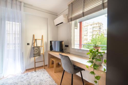 Cette chambre dispose d'un bureau, d'une télévision et d'une fenêtre. dans l'établissement Urban suites- HELEXPO, à Thessalonique