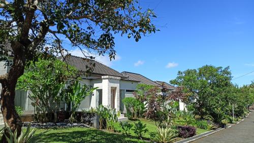 a house on a street with trees and plants at Umadhatu Resort by Amerta in Tabanan