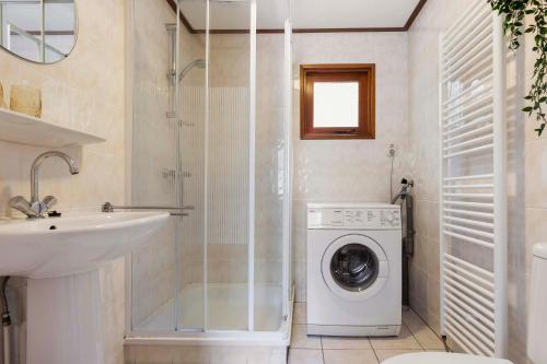 uma casa de banho com uma máquina de lavar roupa e um lavatório em Huize Bosrijk aan het water em Kootwijk