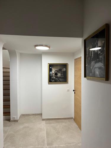 a hallway with a white door and a picture on the wall at Villa Ormarine, vue exceptionnelle sur la baie de Cannes et le Mercantour in Les Adrets de l'Esterel