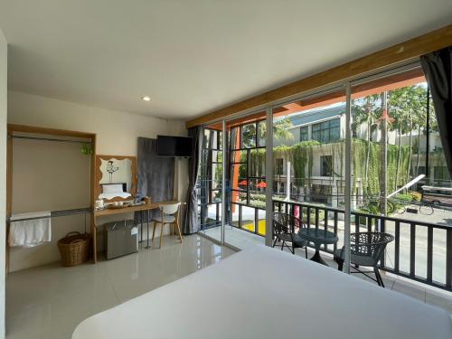 ナイヤンビーチにあるDwell Phuket Airport Hotel at Naiyangのベッド1台付きの客室で、バルコニーを望めます。