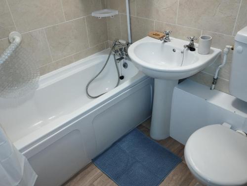 a bathroom with a sink and a toilet and a bath tub at Sunset Retreat - Hunstanton in Hunstanton