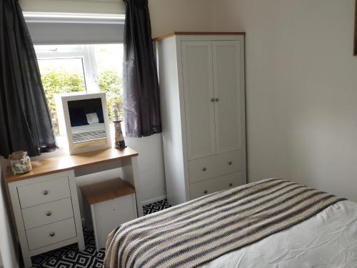 a bedroom with a bed and a desk and a window at Sunset Retreat - Hunstanton in Hunstanton